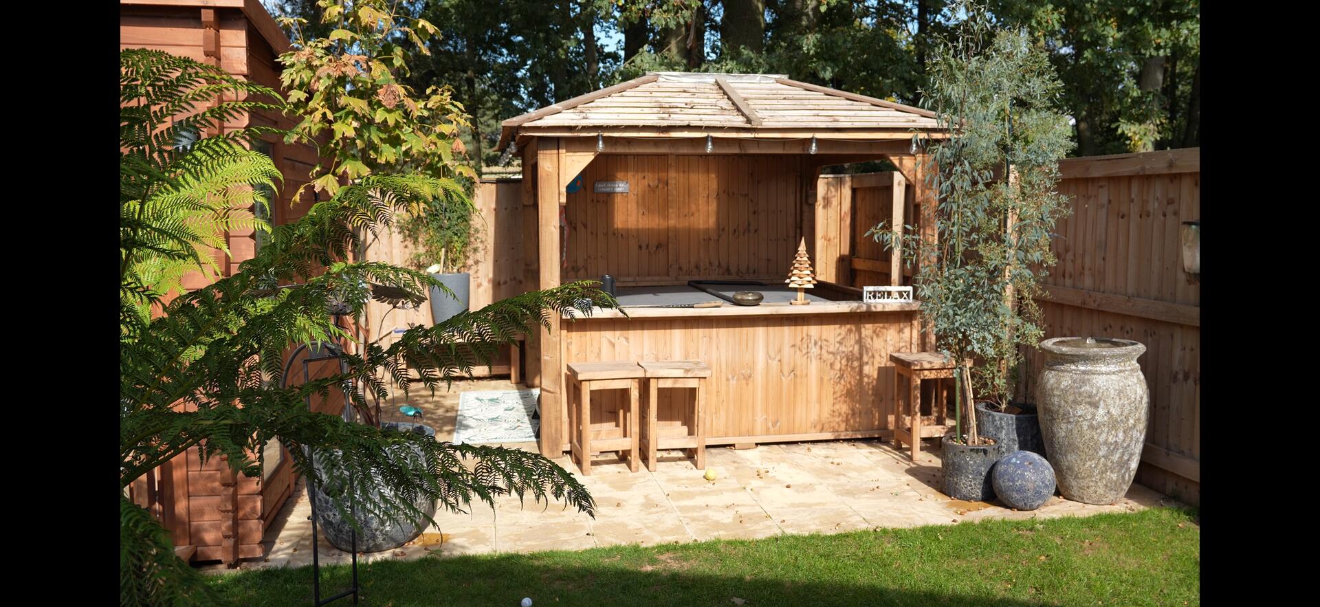 Enclosed garden with timber gazebo, hot tub and planting at Messingham Lakes.